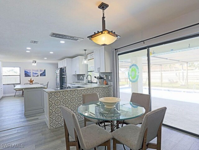 dining space with recessed lighting, baseboards, visible vents, and light wood finished floors