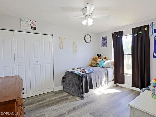 bedroom with baseboards, a closet, a ceiling fan, and wood finished floors