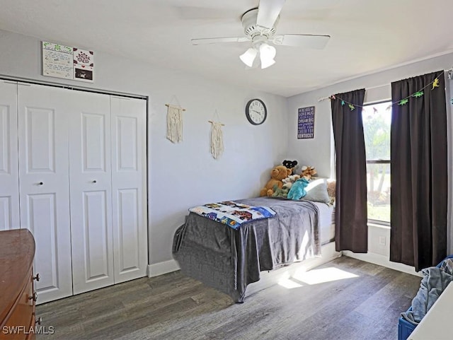 bedroom featuring a ceiling fan, a closet, baseboards, and wood finished floors