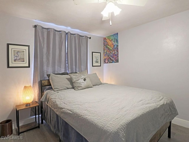 bedroom featuring ceiling fan, baseboards, and wood finished floors