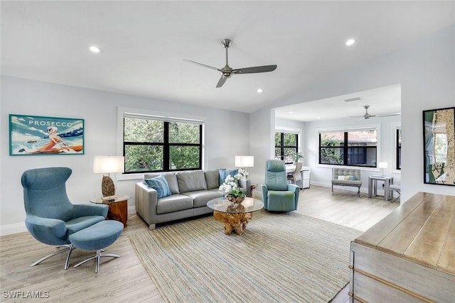 living area featuring light wood finished floors, visible vents, baseboards, vaulted ceiling, and recessed lighting