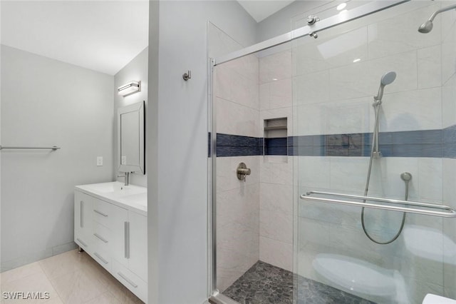 bathroom with double vanity, a stall shower, a sink, and tile patterned floors