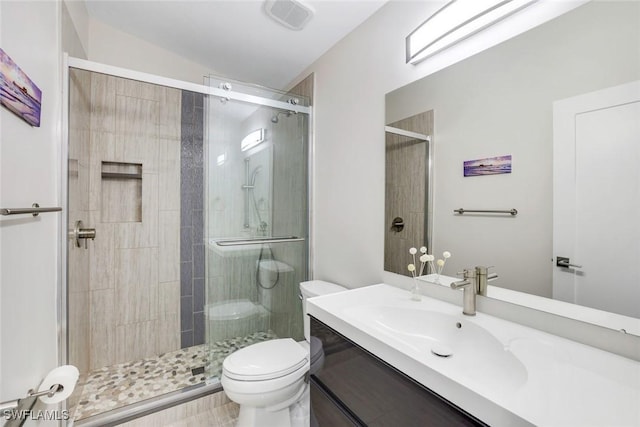 full bathroom with toilet, a stall shower, visible vents, and vanity