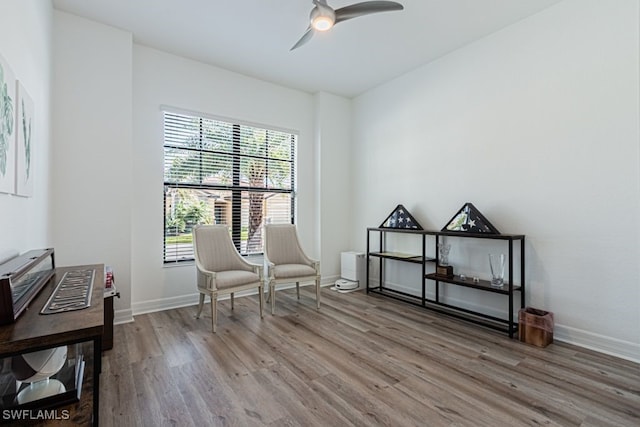 living area with ceiling fan, wood finished floors, and baseboards