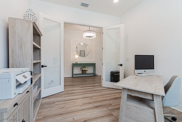 home office featuring light wood-type flooring and visible vents