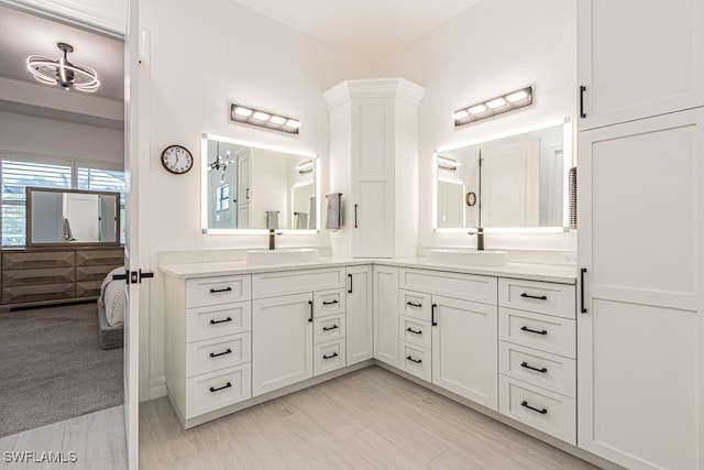 ensuite bathroom featuring wood finished floors, ensuite bath, and vanity