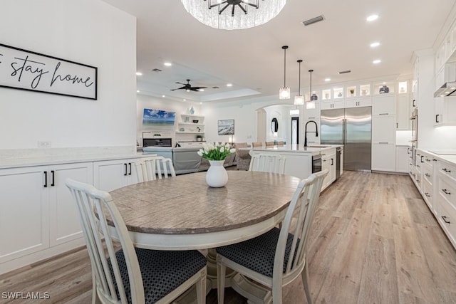 dining area featuring light wood-type flooring, visible vents, arched walkways, and recessed lighting