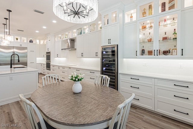 dining area with wine cooler, a notable chandelier, recessed lighting, visible vents, and light wood-style floors