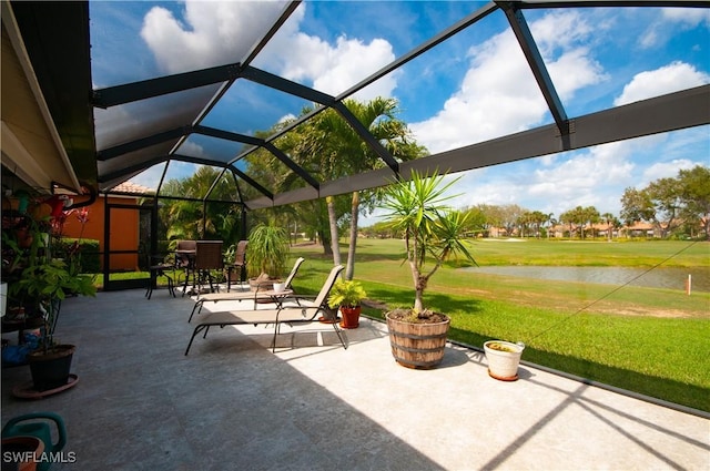 view of patio / terrace featuring a lanai and a water view