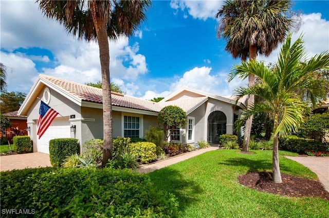 view of front facade featuring a front yard, decorative driveway, an attached garage, and stucco siding