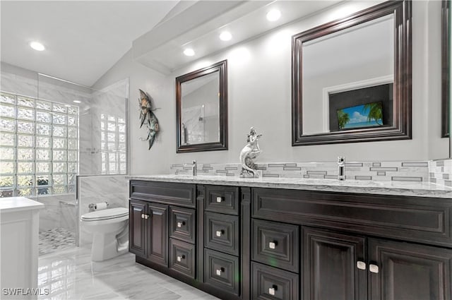 full bath with double vanity, toilet, a sink, marble finish floor, and tile walls