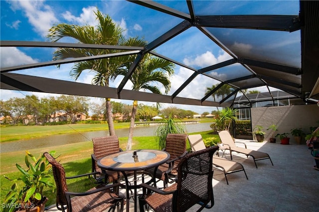 view of patio / terrace featuring a lanai and a water view