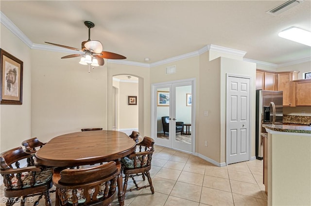 dining area featuring arched walkways, light tile patterned flooring, visible vents, french doors, and ornamental molding