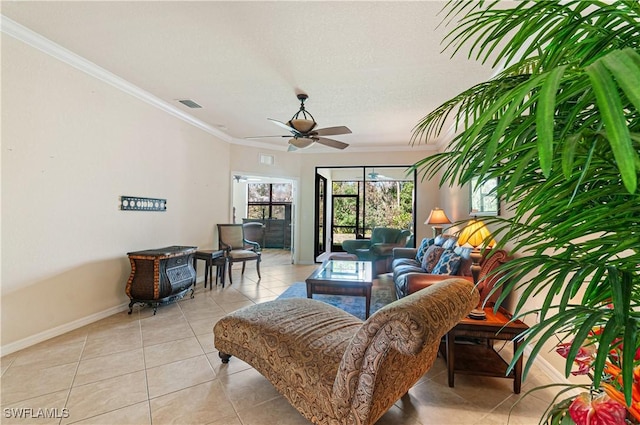 living area featuring light tile patterned floors, visible vents, baseboards, ceiling fan, and crown molding