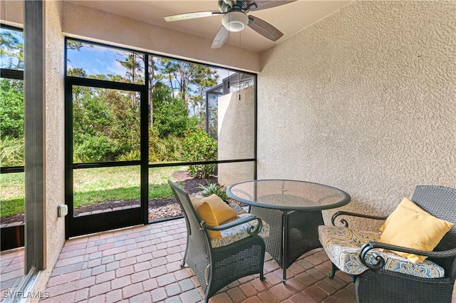 sunroom / solarium featuring ceiling fan