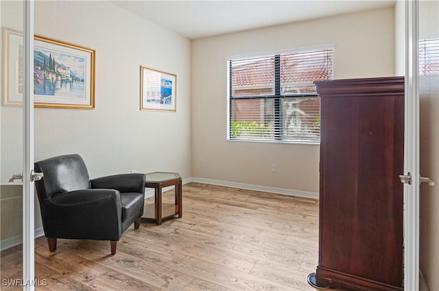 living area with light wood-type flooring and baseboards