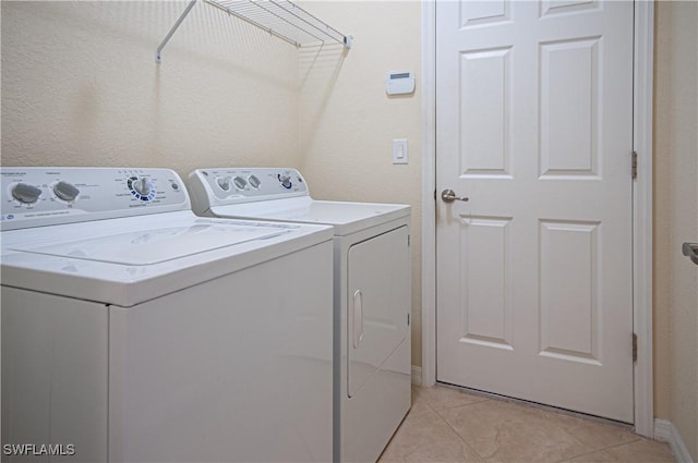 washroom with laundry area, light tile patterned flooring, and washer and clothes dryer