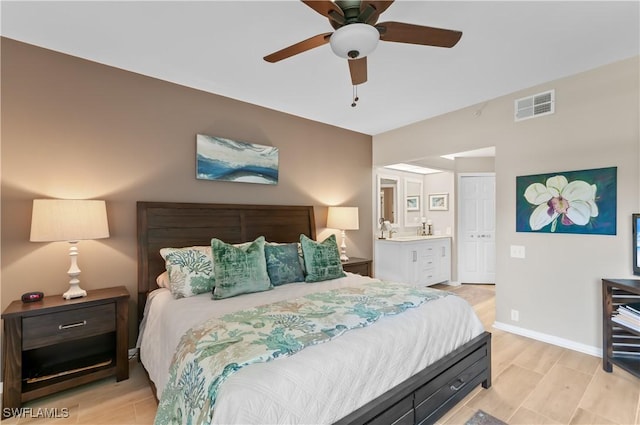 bedroom featuring visible vents, a ceiling fan, ensuite bath, light wood-type flooring, and baseboards