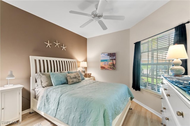 bedroom featuring baseboards, ceiling fan, and light wood-style floors