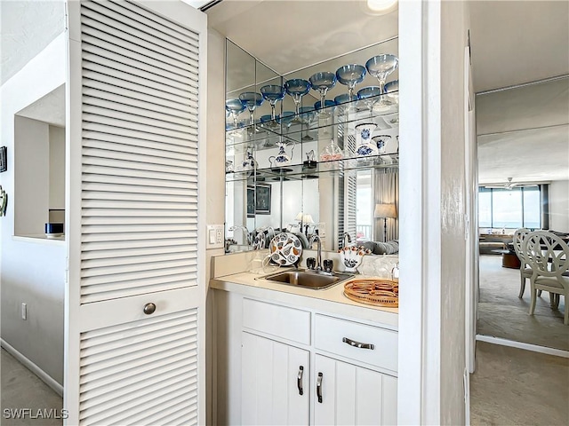 bar featuring concrete floors, a sink, and wet bar