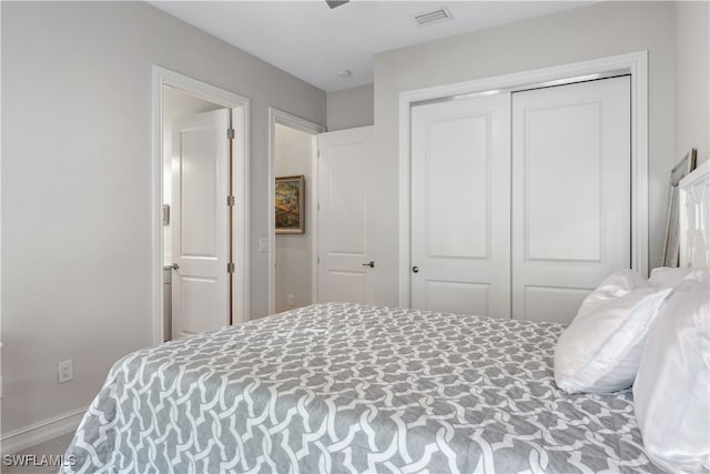 bedroom with baseboards, visible vents, and a closet