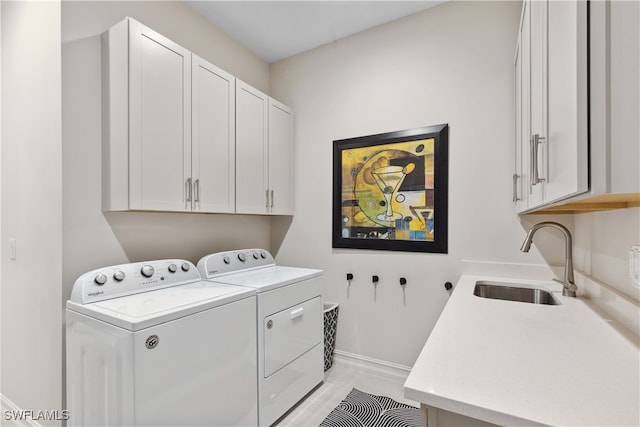 laundry room with washing machine and dryer, a sink, and cabinet space