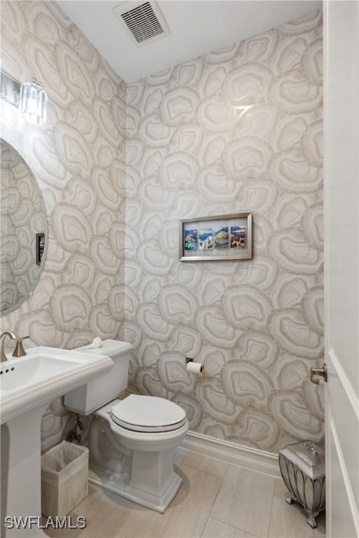 bathroom featuring visible vents, toilet, and wallpapered walls