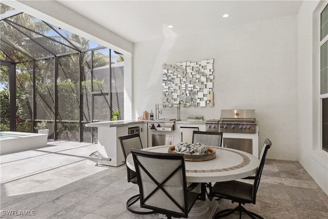 dining space featuring a sunroom, stone tile floors, and recessed lighting