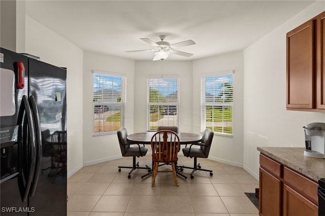 dining room with light tile patterned floors, a ceiling fan, and baseboards