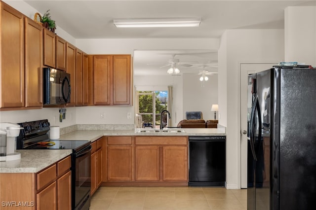 kitchen with black appliances, a sink, light countertops, and brown cabinets