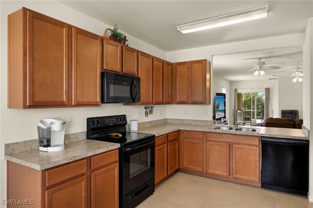 kitchen with brown cabinetry, light countertops, a sink, and black appliances