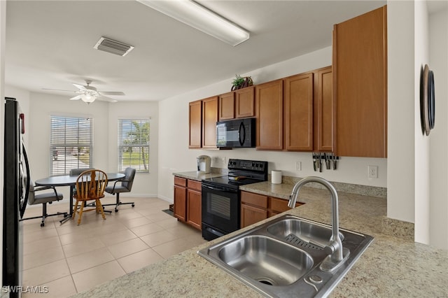 kitchen featuring brown cabinets, a sink, visible vents, and black appliances