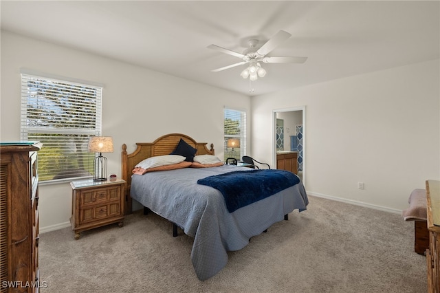 bedroom featuring a ceiling fan, light colored carpet, baseboards, and ensuite bathroom