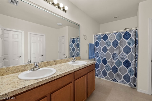 full bathroom with double vanity, tile patterned flooring, visible vents, and a sink