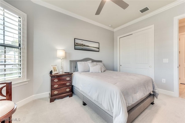 bedroom featuring light carpet, ornamental molding, a closet, and baseboards