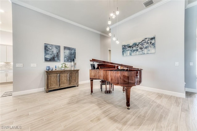 sitting room with crown molding, baseboards, visible vents, and light wood-style floors