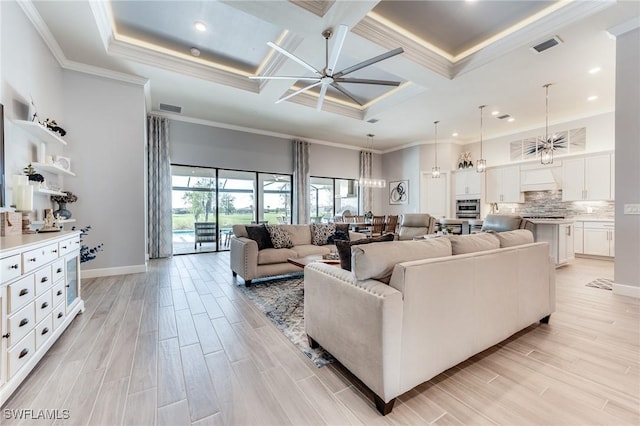 living area with ornamental molding, a high ceiling, and light wood finished floors