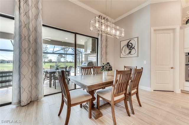 dining area featuring a notable chandelier, a sunroom, baseboards, ornamental molding, and light wood finished floors