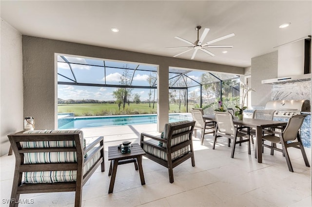 view of patio with outdoor dining area, an outdoor kitchen, an outdoor hangout area, a ceiling fan, and glass enclosure