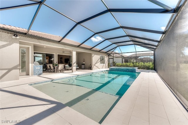 view of pool featuring a lanai, ceiling fan, a pool with connected hot tub, and a patio