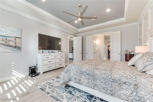 bedroom with light wood-type flooring, ceiling fan, ornamental molding, and a raised ceiling