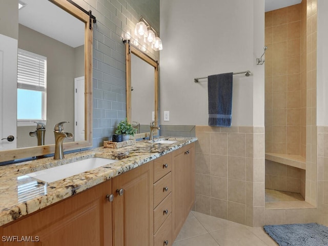 bathroom with double vanity, a sink, tile walls, and tile patterned floors