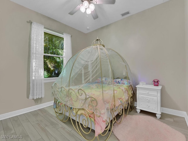 bedroom featuring visible vents, ceiling fan, baseboards, and wood finished floors