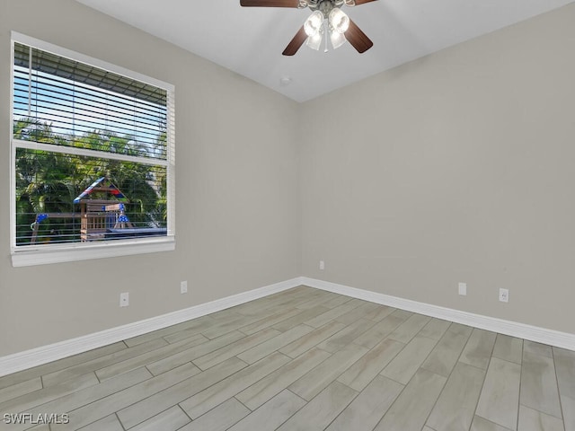 unfurnished room with ceiling fan, wood finished floors, and baseboards