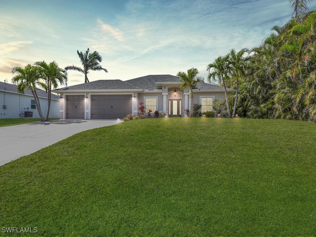 single story home featuring a garage, cooling unit, concrete driveway, and a front yard