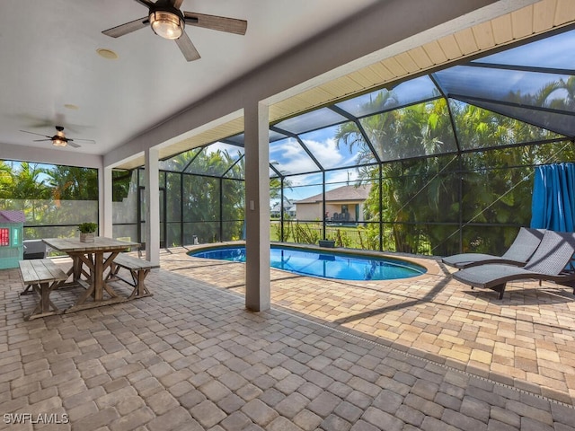 outdoor pool with a lanai, a patio area, and ceiling fan