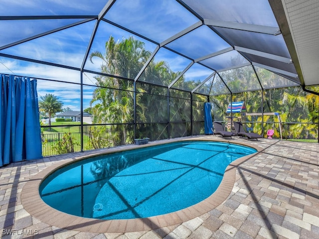 pool featuring a patio and glass enclosure