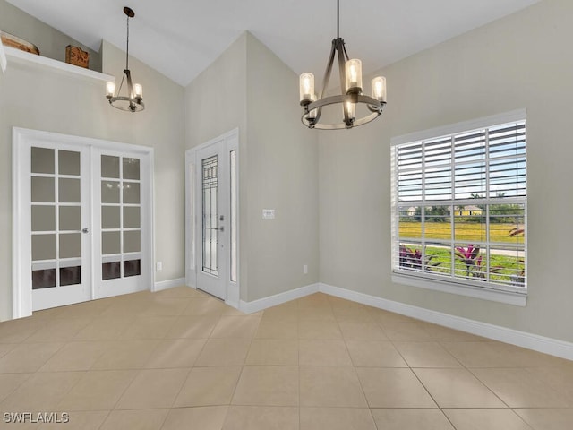 unfurnished dining area with light tile patterned floors, baseboards, vaulted ceiling, french doors, and a notable chandelier