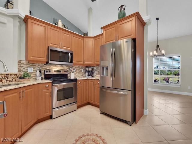 kitchen with lofted ceiling, light stone counters, stainless steel appliances, a sink, and light tile patterned flooring