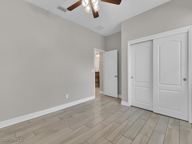 unfurnished bedroom featuring baseboards, visible vents, a ceiling fan, light wood-type flooring, and a closet